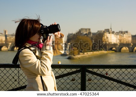 Beautiful tourist in Paris using her camera