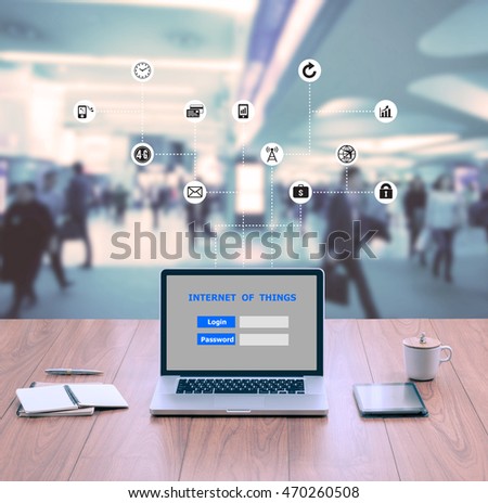 Laptop computer with Internet of things login screen on wood table top with blur business people background