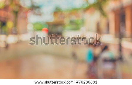 Abstract blurred image of people sitting in outdoor cafe on day time for background usage . (vintage tone)
