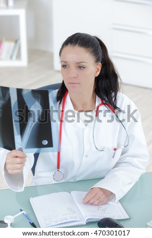 doctor looking at the x-ray picture of hand