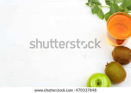 A detox food and healthy energy funny lifestyle concept: A set of healthy sweet testy green and orange fruits and juice for funny party. Top view. On the white wooden background. Free space layout.
