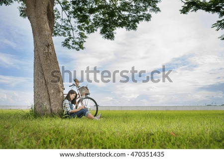 woman using mobile phone under a tree