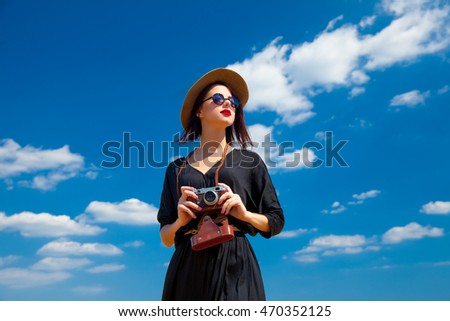 photo of the beautiful young woman with camera in the field
