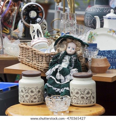 spitalfields antique market. beautiful old doll among household goods at a flea market