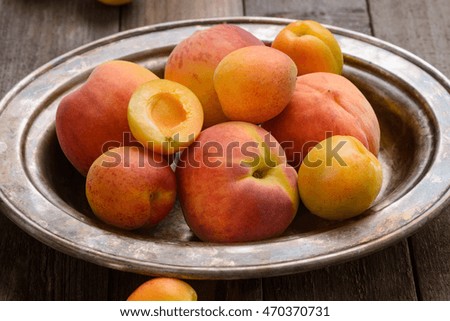 Seductive peaches and apricots served in the silver tray. Close up picture of tasty fruits. Nice meal after working out.
