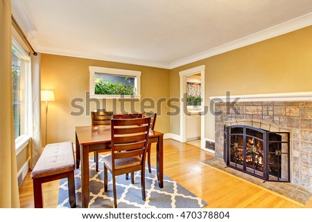 Cozy dining area with wooden table set, hardwood floor and fireplace. Northwest, USA