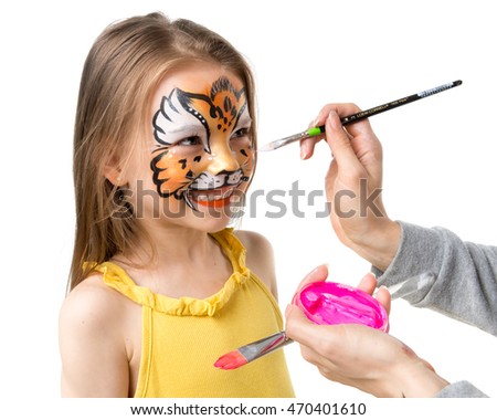 joyful little girl getting her face painted like tiger by artist Royalty-Free Stock Photo #470401610