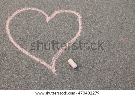 drawing a heart and love letters in chalk on the pavement