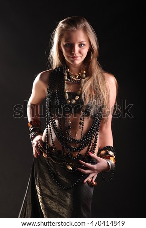 beautiful young girl in beads and bracelets on black background