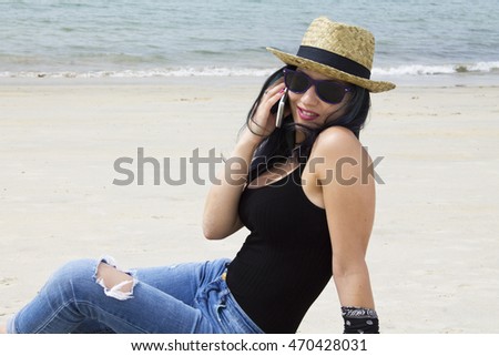 young woman on the beach with mobile phone