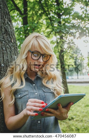Beautiful young girl is shocked looking at her tablet pc