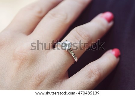 Woman's hand wearing an engagement ring Royalty-Free Stock Photo #470485139