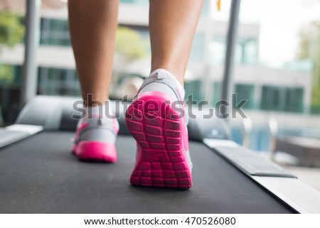 Jogging on treadmill, focus on the treadmill, blurred motion Royalty-Free Stock Photo #470526080