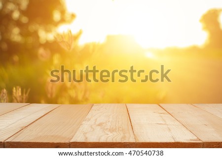 Empty wooden table with autumn for a catering or food background with a country outdoor theme,Template mock up for display of product,Blurred grass in bright morning. Royalty-Free Stock Photo #470540738