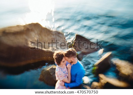Blurred shining picture of a couple standing by the sparkling sea