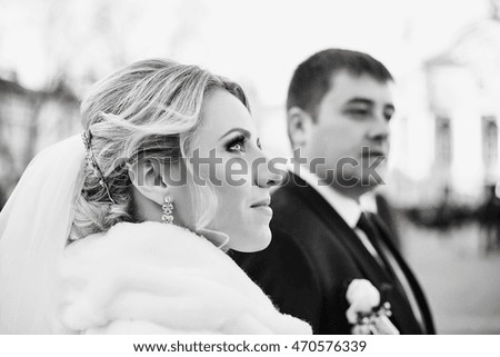 Black and white picture of magnificent bride looking up in the air while standing with a groom
