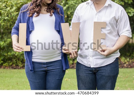 Color maternity photo shoot belly shot with love sign