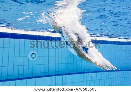 Young female athlete jump into the swimming pool