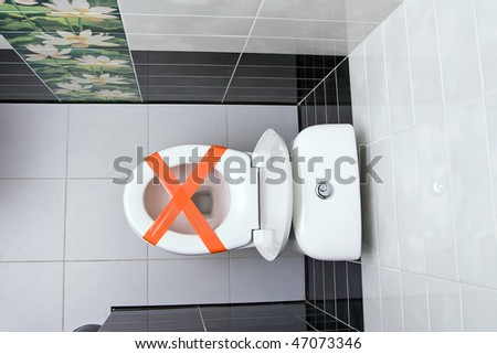 Cross made from adhesive tape, the sign Do not throw trash in toilet
