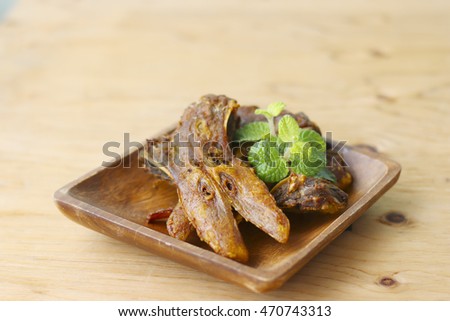 fried platypus on the wood plate.( fried duck mouth)