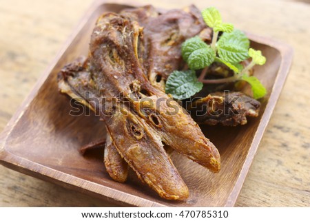 fried platypus on the wood plate.( fried duck mouth)