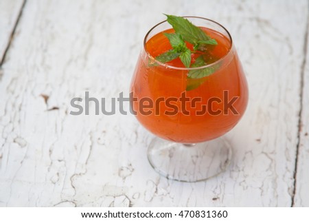 Apricot jam in a glass with mint on wooden background