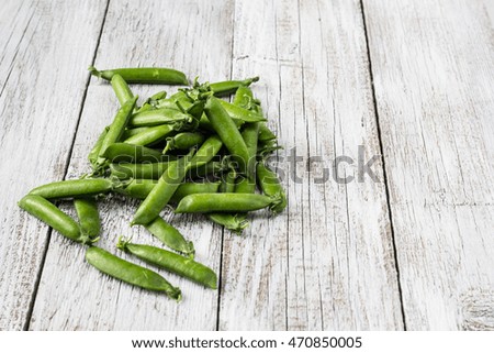 green peas pods on a white wooden table top view, copy space