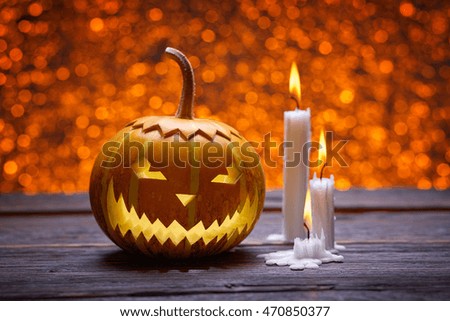 Pumpkin for Halloween, lamp pumpkin, antique wood, celebrating halloween, smiley on a pumpkin, paraffin candles, bright background, angry face, burning candles