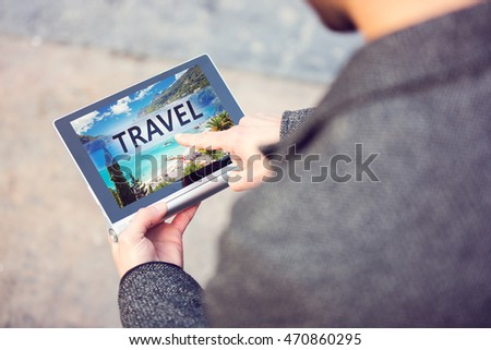 Man using modern digital tablet and pressing on Travel button. Toned photo.