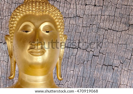 Buddha gold statue close-up on wooden background