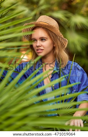 Beautiful woman walking in a wild tropical forest. Young photographer, tourist.