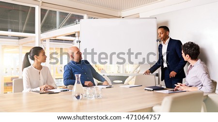 The chairman of the legal firm arrives at the annual general meeting where his 3 other board members sit waiting for him to kick off the meeting. Royalty-Free Stock Photo #471064757