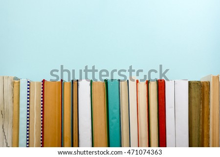 Books on grunge wooden table desk shelf in library. Back to school background with copy space for your ad text. Old hardback   no labels, blank spine