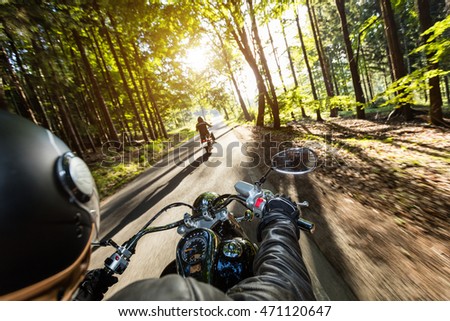 Motorcycle drivers riding on motorway in beautiful sunset light. Shot from pillion driver view Royalty-Free Stock Photo #471120647