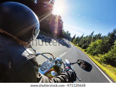 Motorcycle driver riding on motorway in beautiful sunset light. Shot from pillion driver view Royalty-Free Stock Photo #471120668