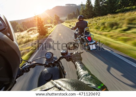Motorcycle drivers riding on motorway in beautiful sunset light. Shot from pillion driver view Royalty-Free Stock Photo #471120692