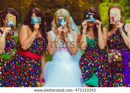 Bride and bridesmaids hold the pictures with them little before the faces