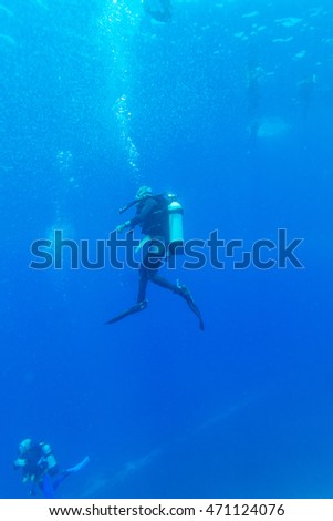 Silhouette of Young Man Scuba Diver between Water Surface and Sea Bottom