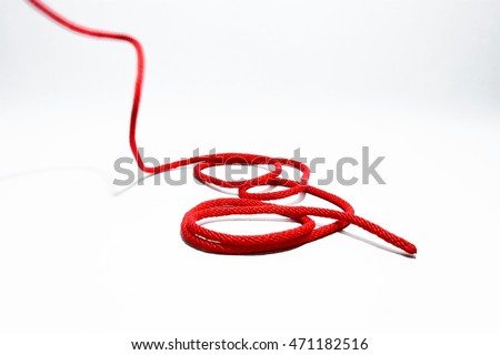 Single red rope thread with roll up on a white background. Royalty-Free Stock Photo #471182516