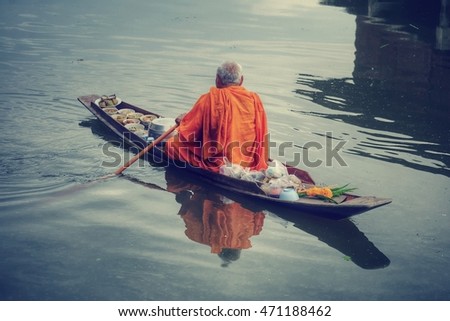 Monk rowing a boat to ask for alms, process hdr / vintage tone