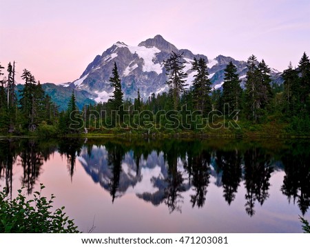 Reflection of mountain in calm water at sunset. Picture Lake and Mount Shuksan  at Mount Baker Ski Area. Cascade Mountains near Bellingham, Washington, USA. 