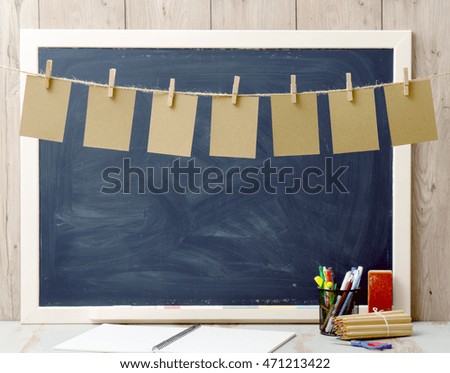 seven sheets of paper hanging and blackboard in background