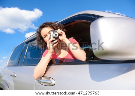 Young girl making photo from car