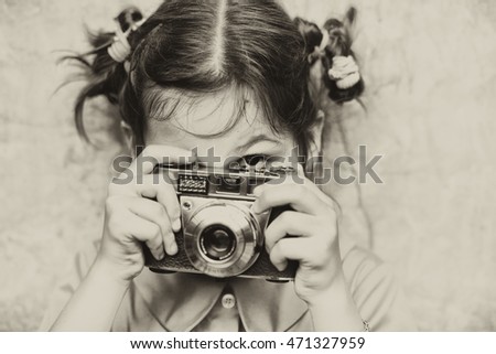Portrait of a little girl with camera/ vintage/ sepia,/old photo/filter