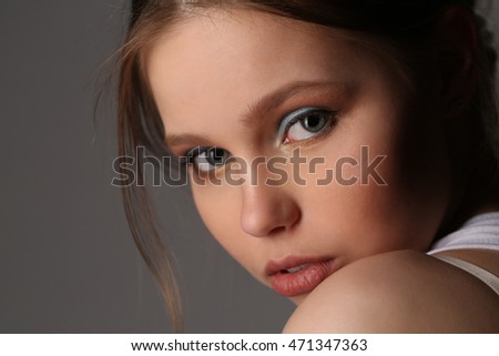 Teen in singlet with makeup. Close up. Gray background