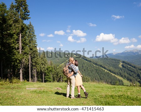 Beautiful traveling couple in love making selfie over mountain panorama