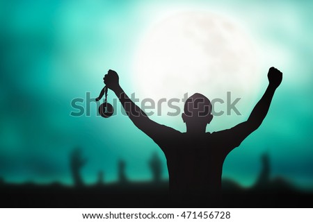 Motivated for winner concept: Silhouette champion hand raised, holding gold medal prize against blurred sports team celebrating Royalty-Free Stock Photo #471456728