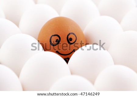 Smiling egg among white eggs