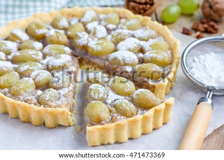Homemade shortbread dough grape tart with walnut praline, horizontal, closeup