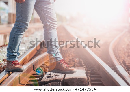 Male tourists are traveling across the tracks. Photo light And toned picture vintage tone.